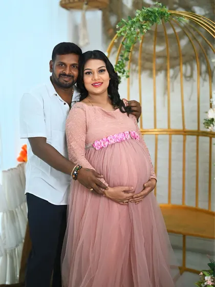 A simple and sweet portrait of an expecting couple. The soft pink gown and the natural light in the studio create a gentle and loving mood.