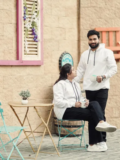 A candid moment during a coffee-themed pre-wedding shoot, capturing a natural and happy interaction.