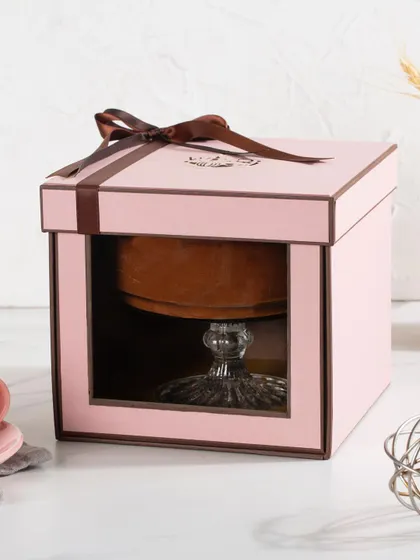 Our single dessert gift box in pink, featuring a clear window to showcase the Dark Chocolate Mousse inside. The box is finished with a simple, elegant brown ribbon.