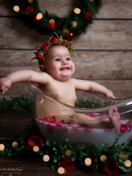 Pure happiness in a tub. This little one is having a great time during her milk bath photoshoot. Her joyful expression is what makes this image so special.