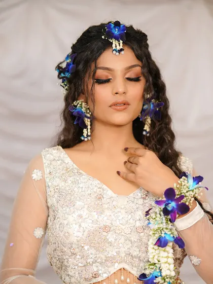 Whites and blooms are a perfect blend for a pre-wedding event. This look features floral jewelry and a soft, ethereal makeup style.