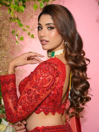 A side profile highlighting the beautiful hairstyle and the flawless contour of her makeup. This look is all about sophisticated glamour.