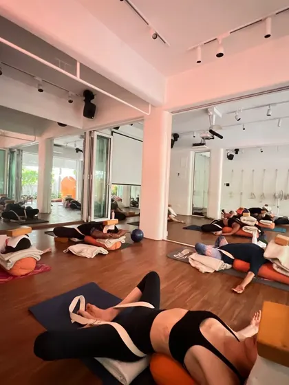 Restoration is non-negotiable in my classes. Here you can see the studio set up for deep rest, with every student supported by bolsters, blocks, and straps to completely let go.