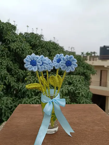 A small vase of blue daisy stems.
