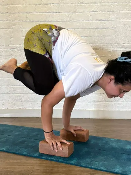 The smile of achievement. This TTC student embodies the joy and empowerment that comes from mastering a challenging pose like Bakasana, a milestone in her journey to becoming a teacher.