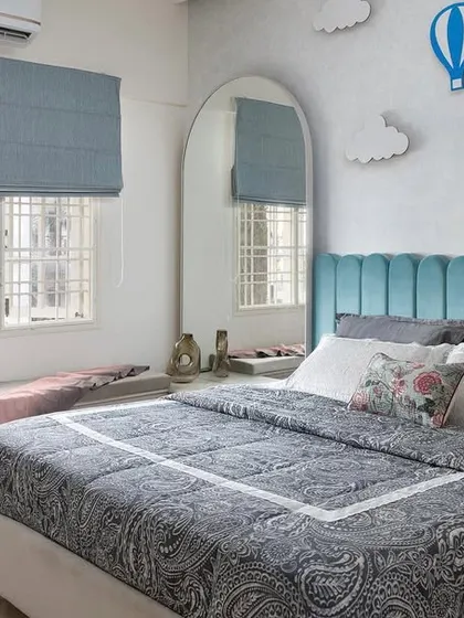We designed this child's room to be both playful and timeless, with a sky-blue channel-tufted headboard, cloud and hot-air balloon wall decor, and a cozy window seat with built-in storage.