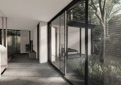 The interiors of our Dona Paula homes reflect the dynamic, shifting roofs of the architecture. This space features curved, sloping ceilings and minimal furniture, with carved courtyards bringing filtered light to the lower floors.