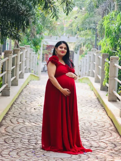 This classic red maternity gown with cap sleeves is a timeless choice. It provides a beautiful silhouette and a pop of color for outdoor photoshoots on pathways and bridges.