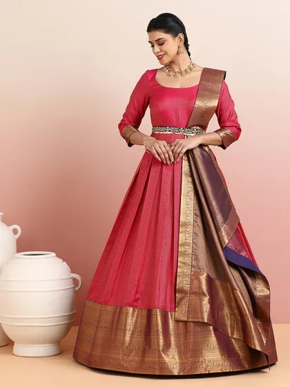 A beautiful pink and deep blue half-saree lehenga with a wide gold zari border. The three-quarter sleeves and elegant drape make it a graceful and timeless choice.