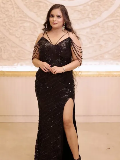 A full-length shot showing off her glamorous black gown with a thigh-high slit. The makeup is chic and sophisticated, perfect for a red carpet vibe.