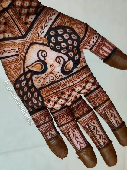 A close-up of a design with two peacocks facing each other, a symbol of love and partnership, making it perfect for bridal mehndi.