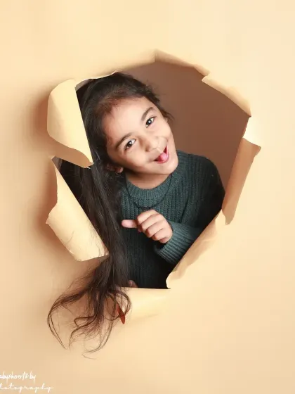 A playful wink and a cheeky expression make this shot from the paper-tear series a standout.