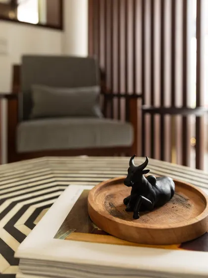 Beauty is in the details. The stunning mother-of-pearl inlay coffee table, paired with a handcrafted Nandi sculpture, adds a touch of Indian elegance and sophistication.