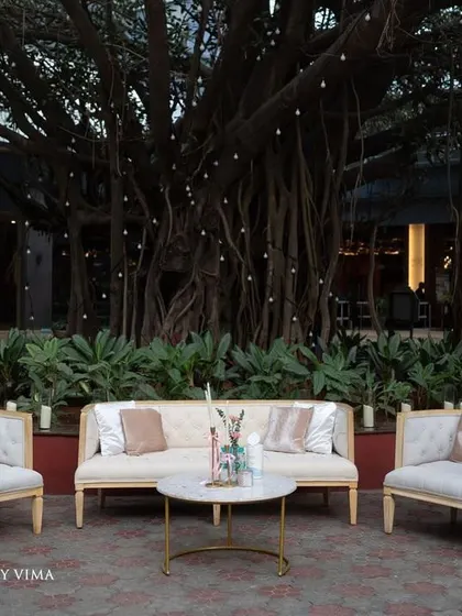 An elegant and cozy lounge area for a minimalist reception. We used chic white sofas and chairs, surrounded by lush greenery and the warm glow of candles, creating a perfect space for conversation.