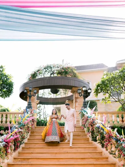 The couple makes their grand entrance down a beautifully decorated staircase for their Mehendi ceremony at Della Resorts, Lonavala.