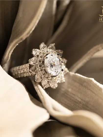 A sparkle that lasts forever. Our exquisite oval-cut diamond ring with a floral halo is a timeless piece of art.