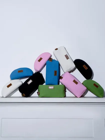 A vibrant pile of multi-colored pouches against a clean white background. This shot is a simple but effective way to showcase the full range of colors available for a product on a webshop.