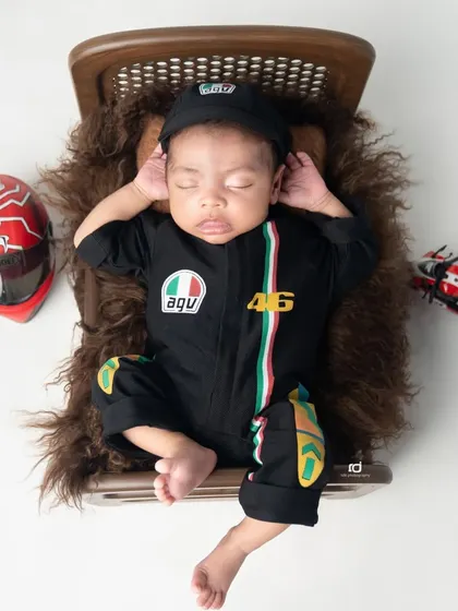 Born to ride. This little biker boy in his racing suit is dreaming of the open road.