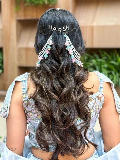 A personalized hairstyle for a mehendi ceremony, with a custom hairpiece featuring the groom's name, "Harsh".