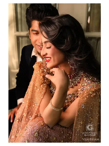 A joyful and intimate moment from the Hollywood glamour shoot. The makeup looks flawless and radiant, with a classic red lip that enhances the model's happy expression.