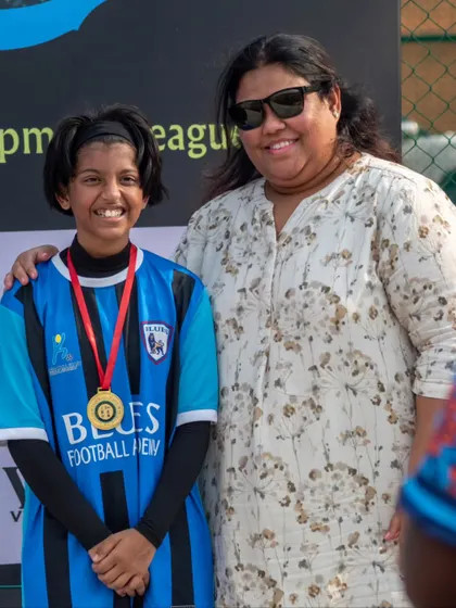 A young player proudly wears her medal after being recognized for an outstanding performance. We believe in celebrating every achievement.