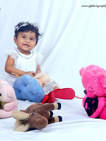 A classic studio setup with a clean white backdrop and soft toys creates a timeless portrait. We ensure the environment is playful and engaging for the baby, resulting in natural smiles.