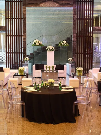A chic and modern lounge setup for a corporate event, with black and white furniture and clean floral arrangements. We cater to all types of events, ensuring a sophisticated ambiance.
