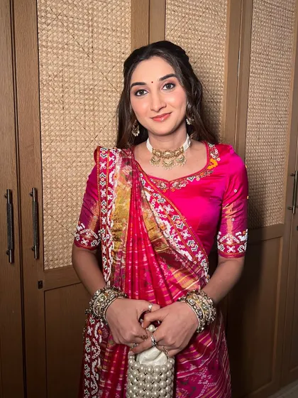 A soft glow for this client in a vibrant pink patola saree. The makeup is kept minimal to let the outfit shine.