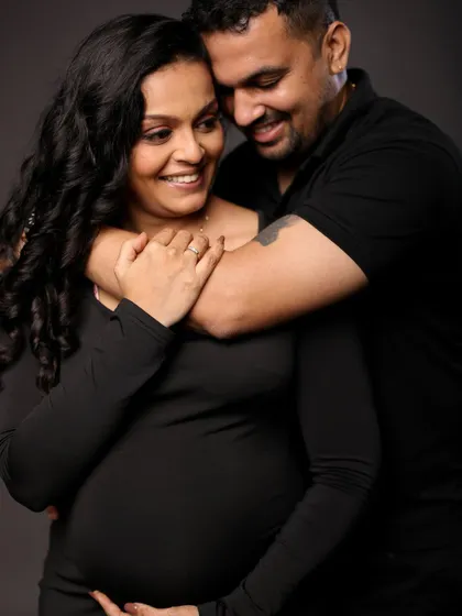 A joyful and intimate embrace, their smiles lighting up this beautiful black and white studio portrait.