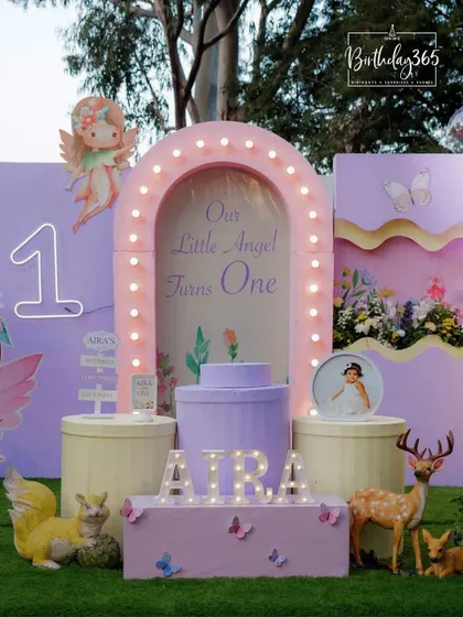 Aira's first birthday was an enchanted fairy tale. The main stage featured a lighted arch, her name in marquee letters, and woodland creatures like deer and squirrels.