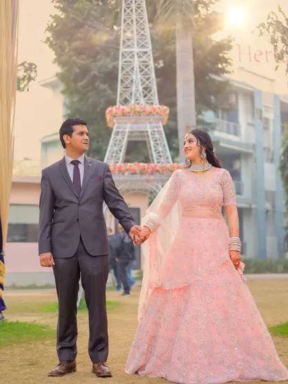 A romantic shot of the couple during their pre-wedding shoot, with an Eiffel Tower replica and beautiful backlighting.