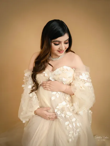 A seated pose, looking down at your bump, is both comfortable and elegant. It allows for a beautiful, intimate portrait that focuses on your connection with your baby.