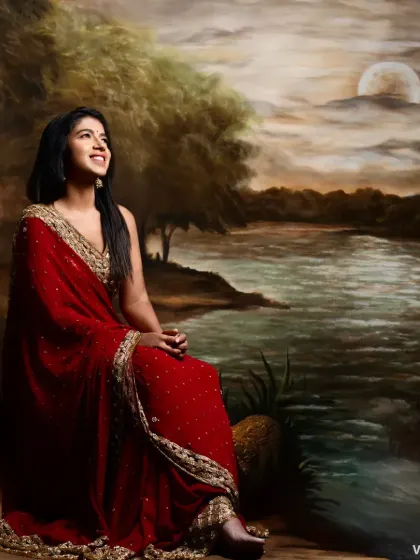 A full view of the maroon georgette saree against an artistic backdrop. This is a classic and elegant choice for a reception or formal family function.