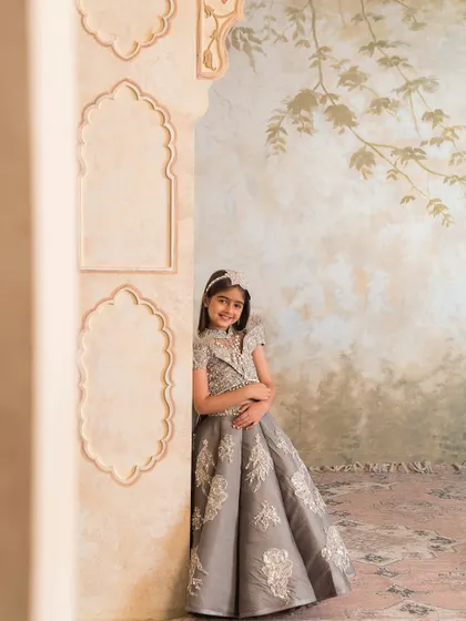 The structured skirt and embellished blouse create a sophisticated silhouette, perfect for a wedding reception.