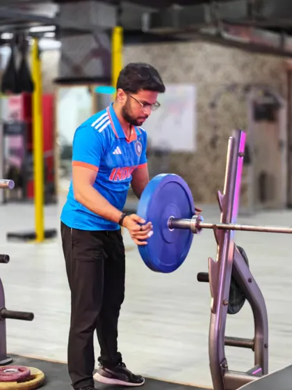 A client loads a barbell for his next set. We teach you how to train with purpose, from setting up your equipment to executing the lift perfectly.