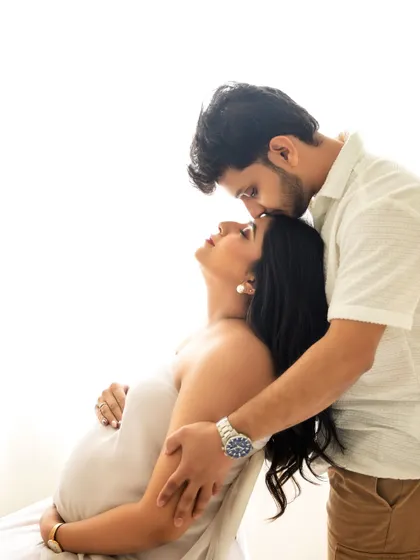 A tender forehead kiss is a simple yet powerful pose that conveys so much love and care. It's a favorite in my couple maternity sessions.