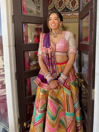 The bride in her colorful Mehndi outfit. The braided hairstyle keeps her hair neatly off her shoulders, which is practical for the ceremony.