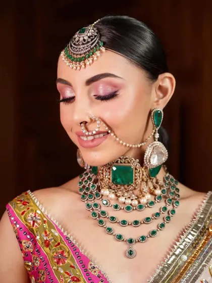 A beautiful close-up of a smiling bride. The makeup features a soft pink eyeshadow and glowing skin, a perfect look for a mehendi or sangeet ceremony.