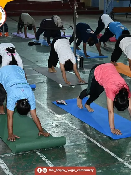 Students in Parvatasana (Downward-Facing Dog) during the 108 Surya Namaskara challenge. The sight of everyone moving together is a powerful symbol of unity.