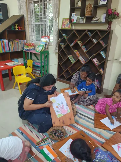 A storyteller shows an example of the drawing for the day's craft. This visual guide helps children get started with their own creations.