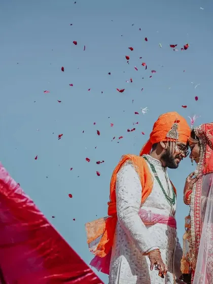 A beautiful moment after the Varmala, with the couple sharing a connection as flower petals rain down on them.