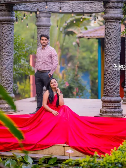 A regal pose on the steps of the stone structure. The bride is seated, her red gown spread out before her, creating a powerful and elegant composition.