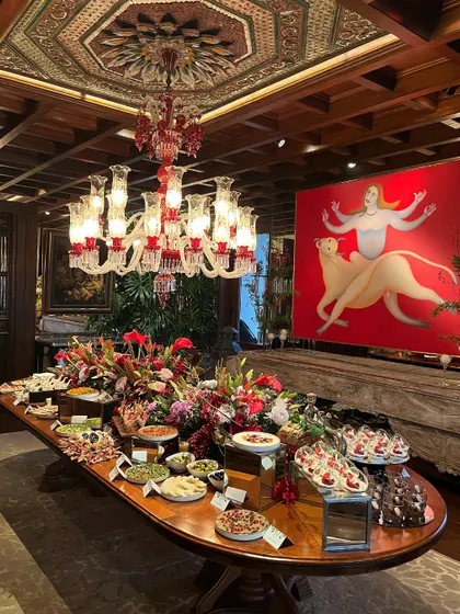 A magnificent, full-length grazing table in a grand room, showcasing our ability to cater to large, upscale events. The spread includes a wide variety of dishes, from savory platters to desserts, all artfully arranged to impress guests.