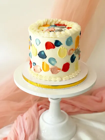 An abstract and artistic cake with colorful daubs of buttercream, resembling an artist's palette. This design is simple, modern, and full of personality.