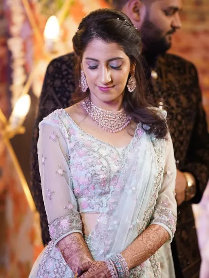 A candid moment of the bride during her Sangeet. The soft lighting highlights the subtle shimmer on her eyes and the smooth finish of her makeup.