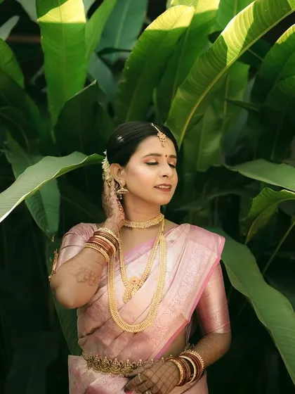 An elegant portrait of a South Indian bride, showcasing her traditional gold jewelry and hairstyle.