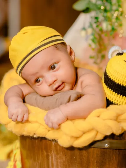 Our sweet little honeybee. This newborn is wide-eyed and curious in a charming bumblebee-themed setup with soft, yellow textures.