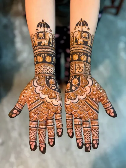 A grand bridal design featuring the couple's initials, "AS," on the forearm. The design is rich with traditional motifs like elephants, swans, and lotuses.