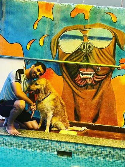 A pet parent shares a quiet moment with his dog, Bruno, by the poolside. This image captures the strong bond between humans and their pets, which we love to foster in our relaxed and friendly environment.