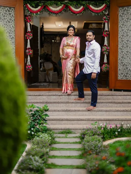 A beautiful portrait of the expecting parents at the entrance of their home, ready to welcome their new chapter.